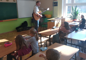 Pan Krzysztof tłumaczy dzieciom wysokość dźwięków